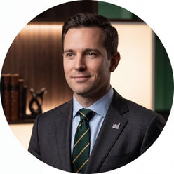 Circular portrait of Derek Miller, a professional man in business attire, smiling confidently against a clean background.